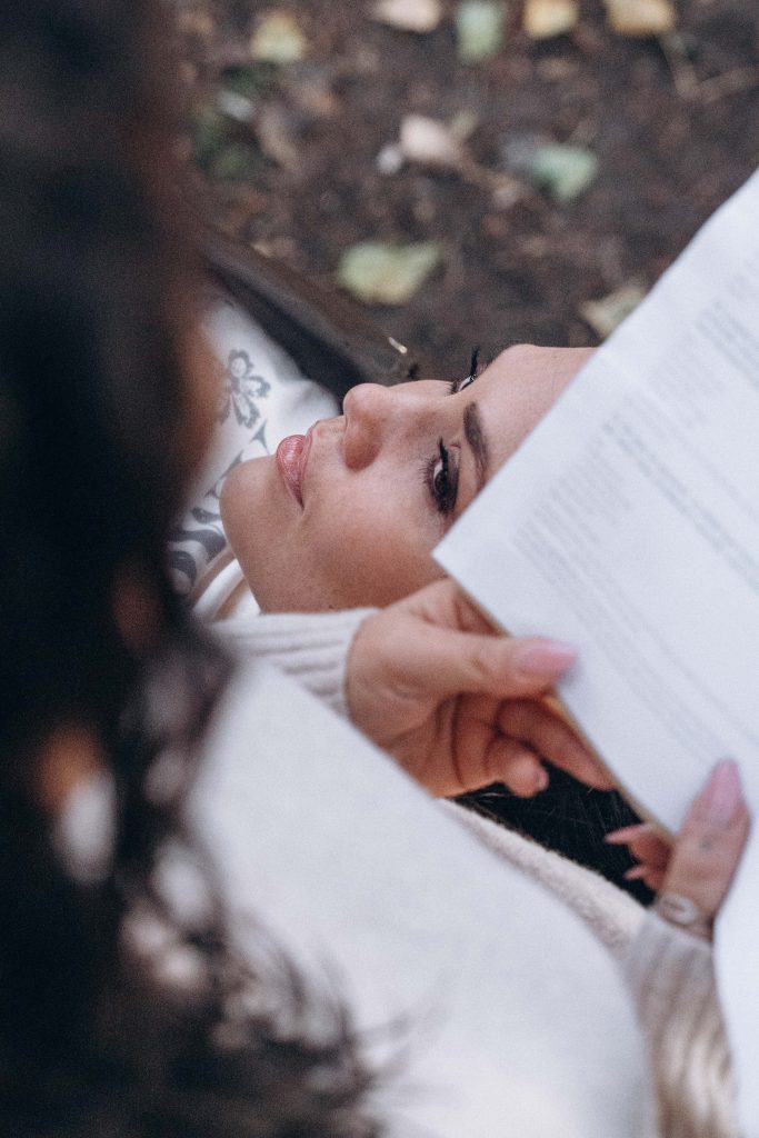 Femme allongée dans les feuilles d'automne souriante en lumière dorée, séance photo lifestyle