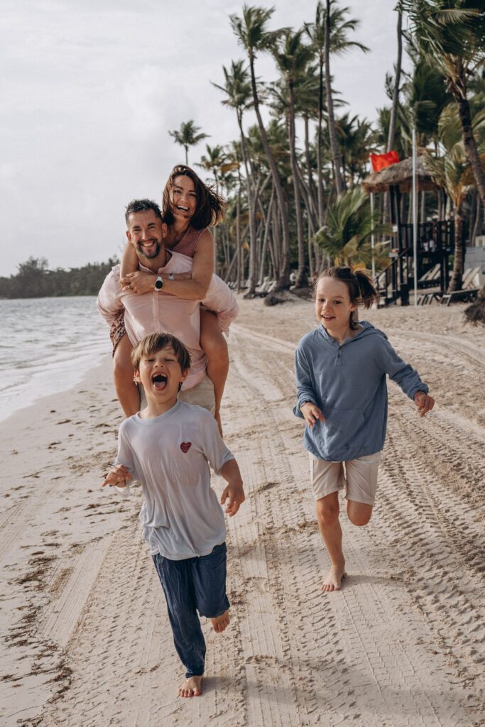 Enfants courant joyeusement sur la plage en famille, séance photo de famille au bord de la mer